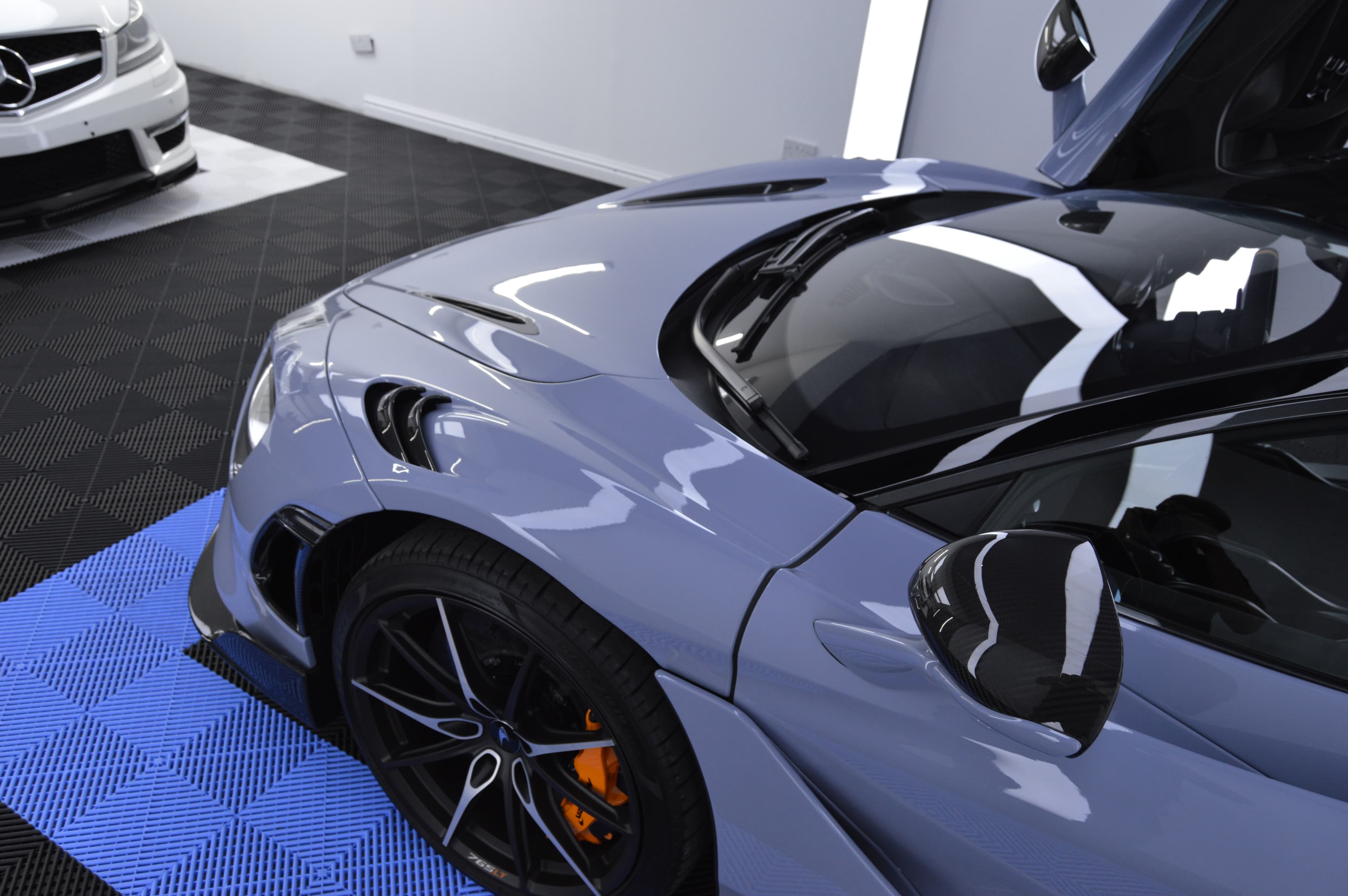 McLaren 765LT front-left quarter, orange caliper, carbon mirror